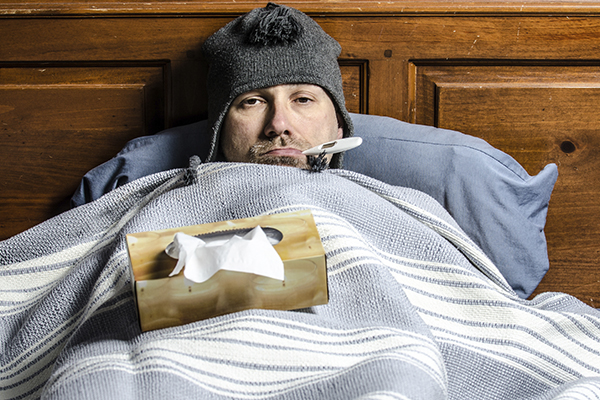 Sick in Bed with Thermometer