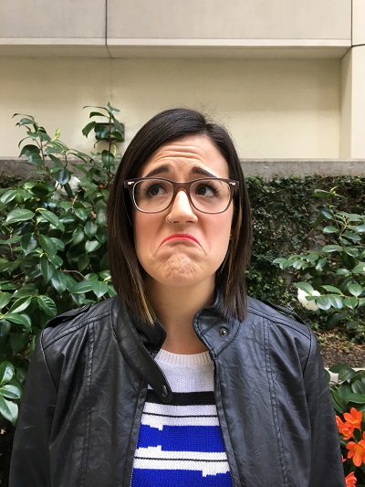 Girl in glasses and leather jacket sad and frowning