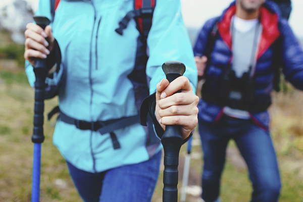 Nordic walking couple with jackets and poles