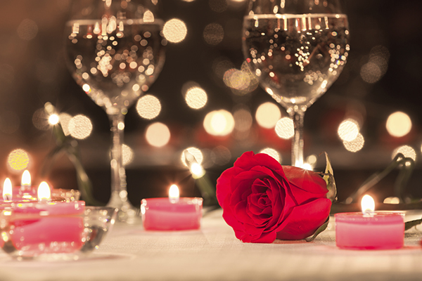 Two wine glasses and candles on dinner table