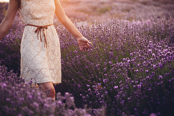 Woman in white dress walking through flowers