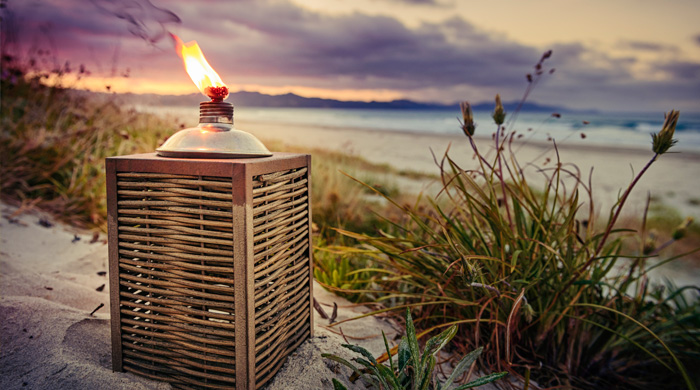 Citronella candle bug lantern on the beach at sunset