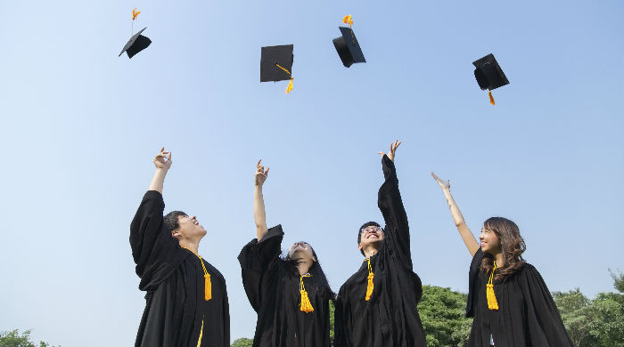 Graduates throwing caps into the air