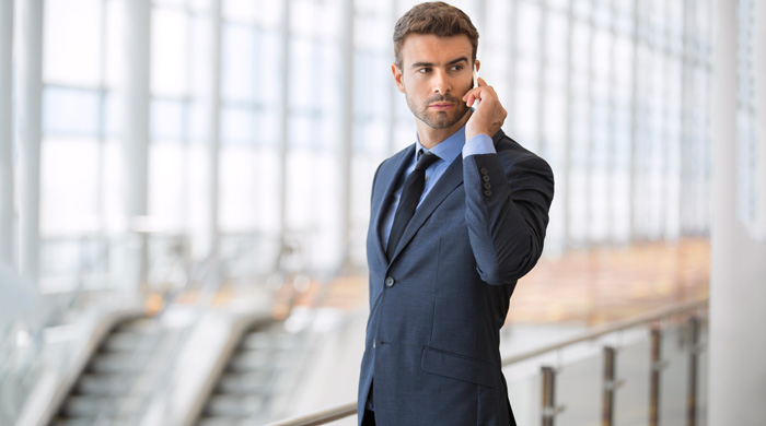 Man wearing a suit talking on a cell phone