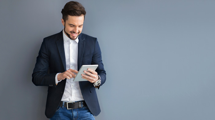 Man wearing a blazer using a tablet