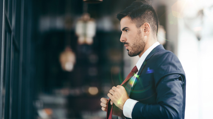 Man in suit adjusting his tie