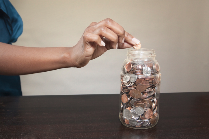 Woman putting coin into jar