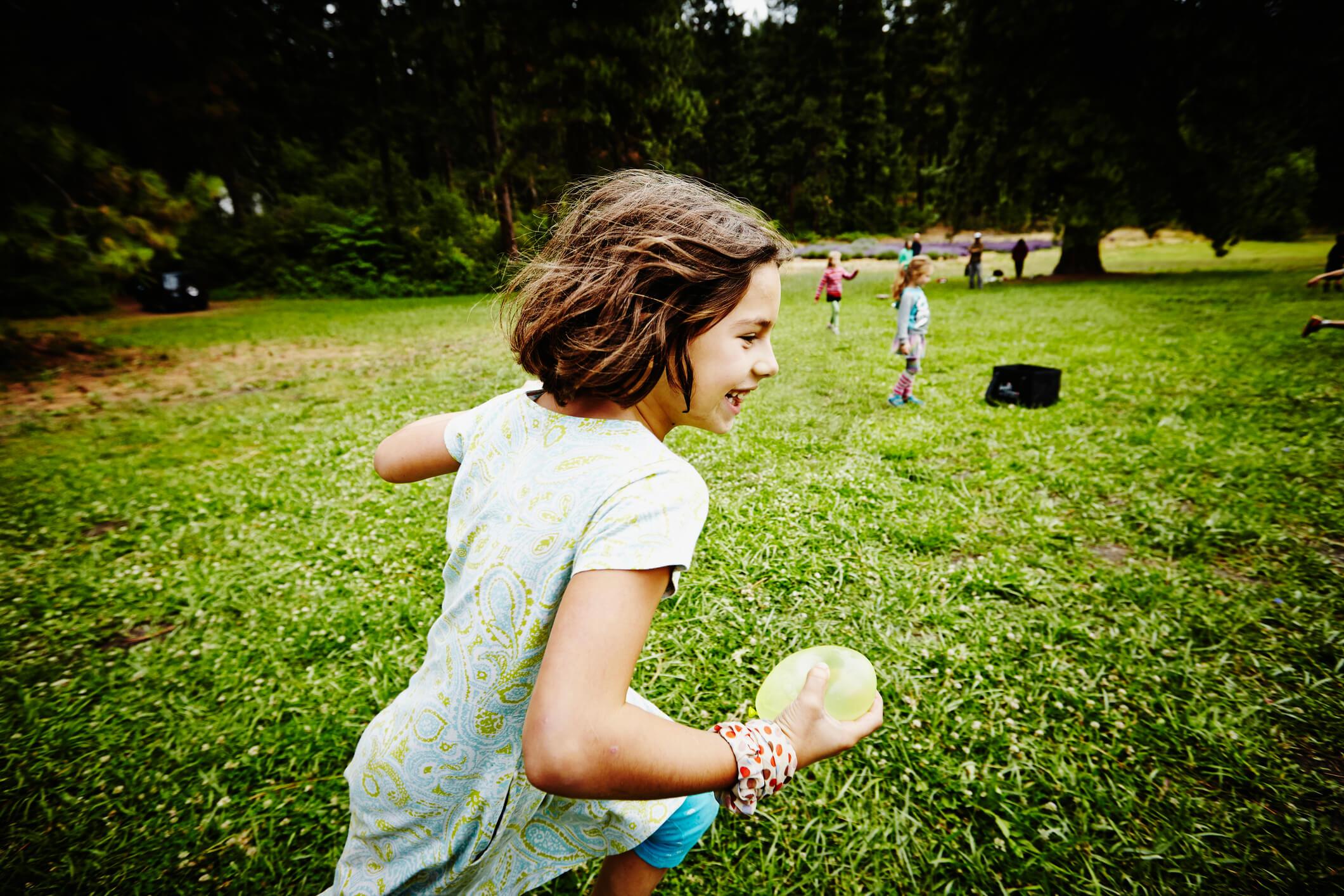 Little girl running and playing on grass