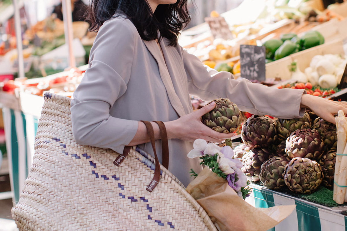 Woman carrying a shopping bag and buying produce