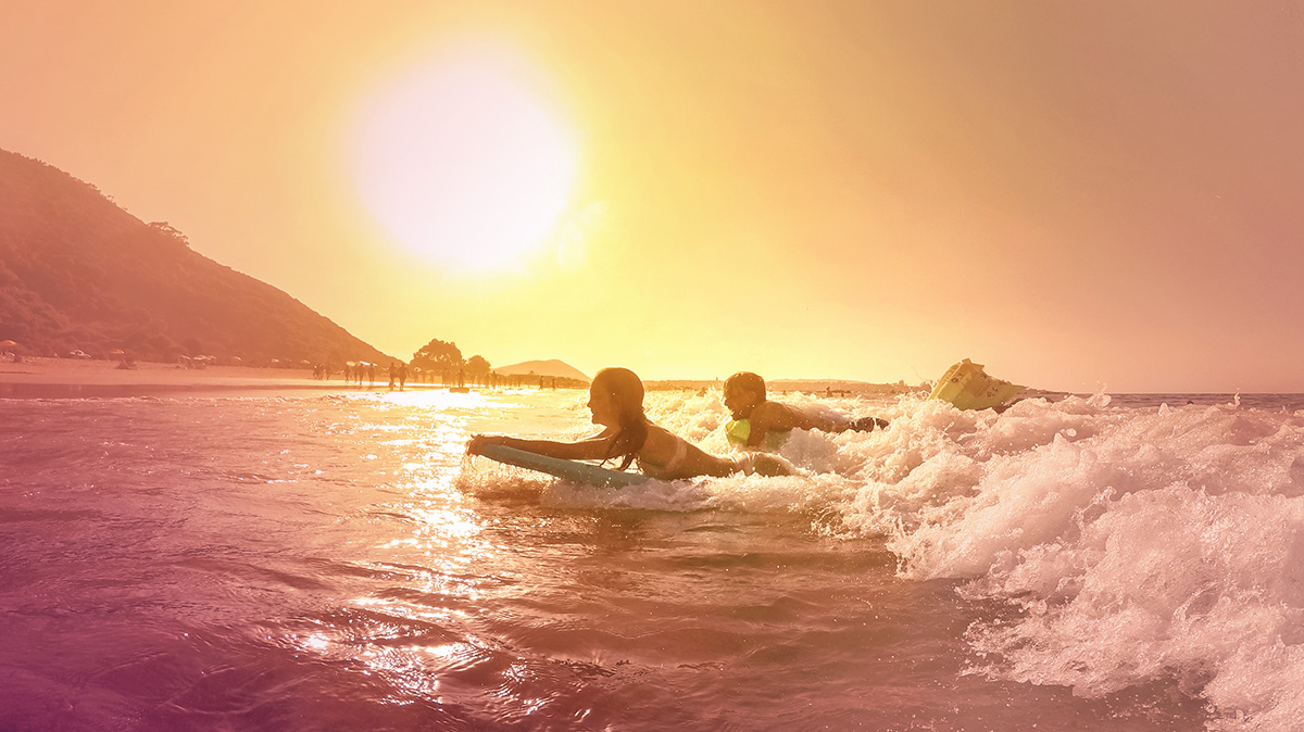 People surfing at sunset