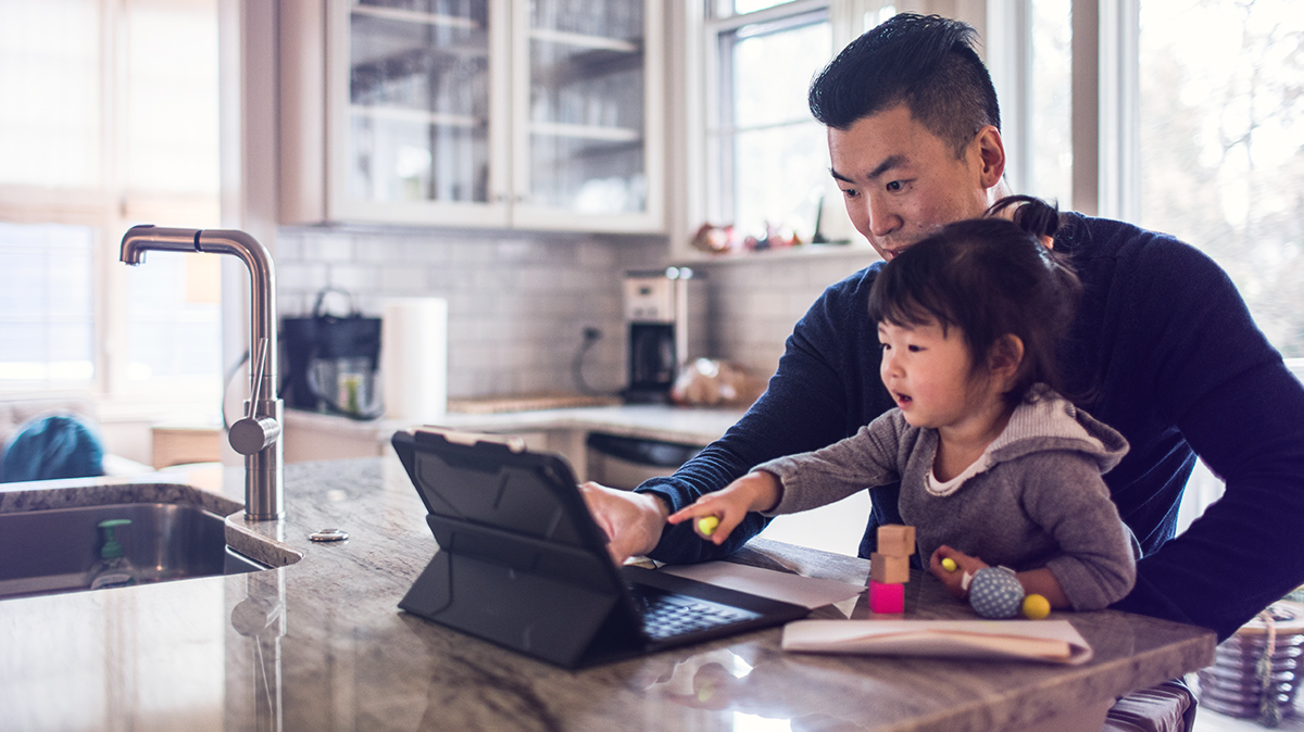 Father and daughter looking at a laptop