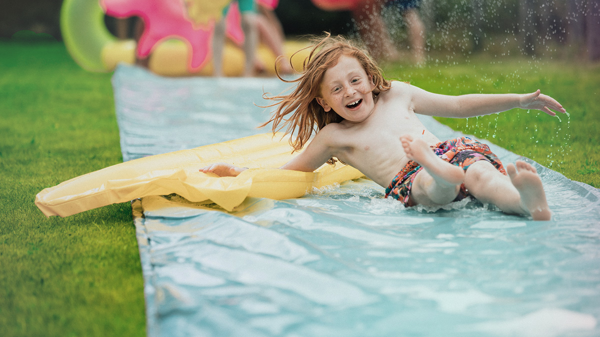 Young boy playing on slip 'n' slide