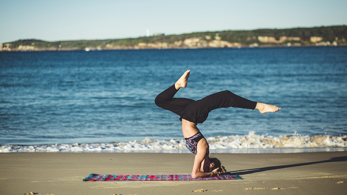 A woman doing yoga on the beach