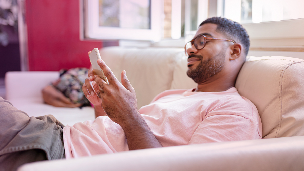 Guy using his phone on the couch