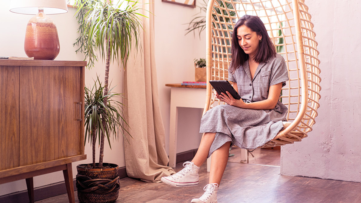 Girl in hanging chair on tablet