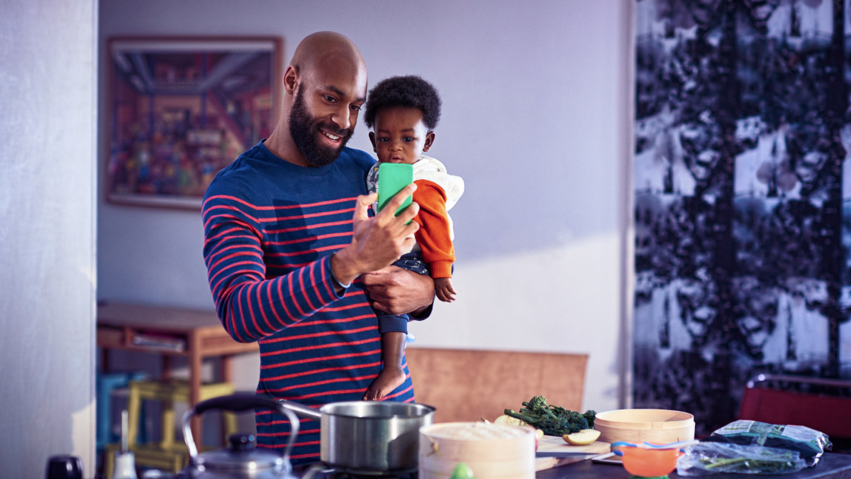 Man carrying baby using smartphone