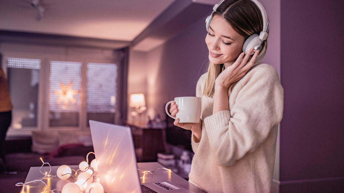 Woman wearing headphones and using laptop