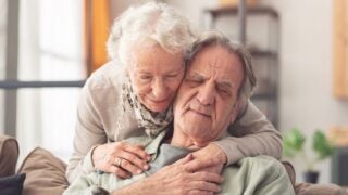 Older woman hugs older man