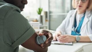 Patient checks his blood sugar levels with clinician