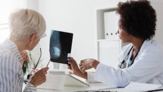 Older woman and clinician look at breast X-ray