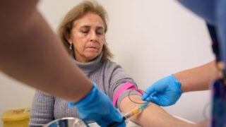 Nurse drawing blood sample from patient